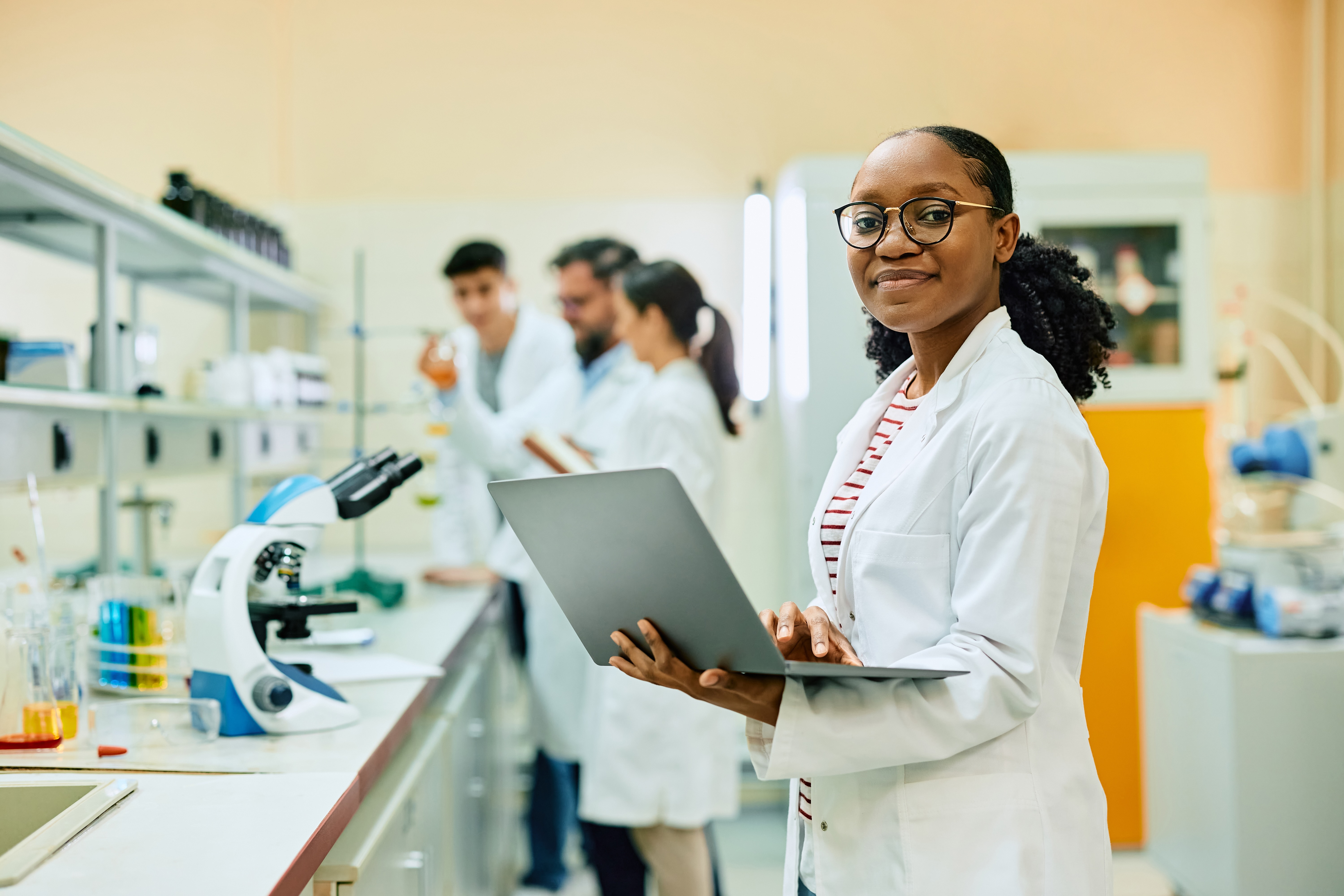 A team of scientists collaborating inside a modern laboratory setting, representing how QReserve maps core data architecture and deploys secure infrastructure while keeping active researcher workflows completely undisturbed.